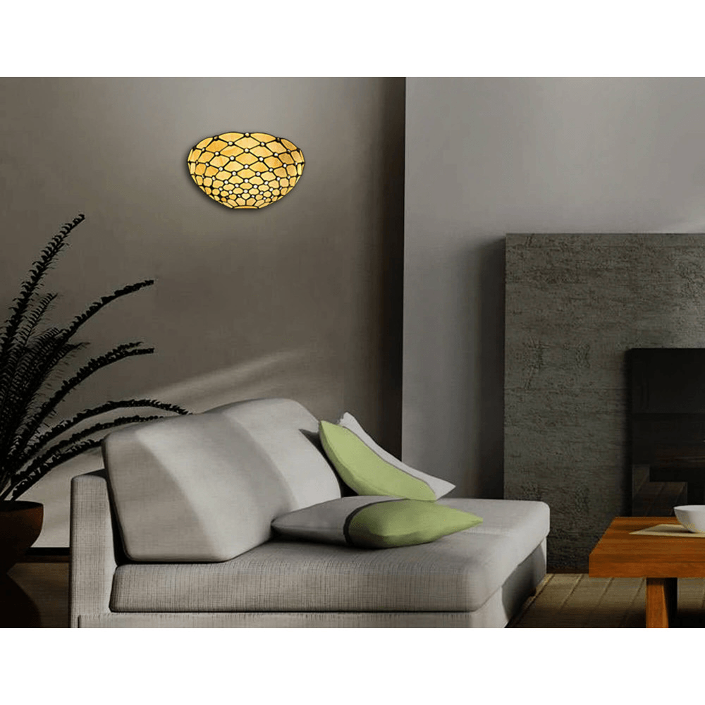 Tiffany Designer Wandleuchte mit funkelnden Glas-Edelsteinen, installiert in einem modernen Wohnzimmer über einem gemütlichen Sofa mit Kissen.