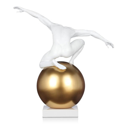 Skulptur „Beherrschung groß“ - Moderne figurative Kunst aus satiniertem Kunstharz mit goldener Kugel und Marmorsockel, zeigt eine anthropomorphe Figur in akrobatischer Pose.