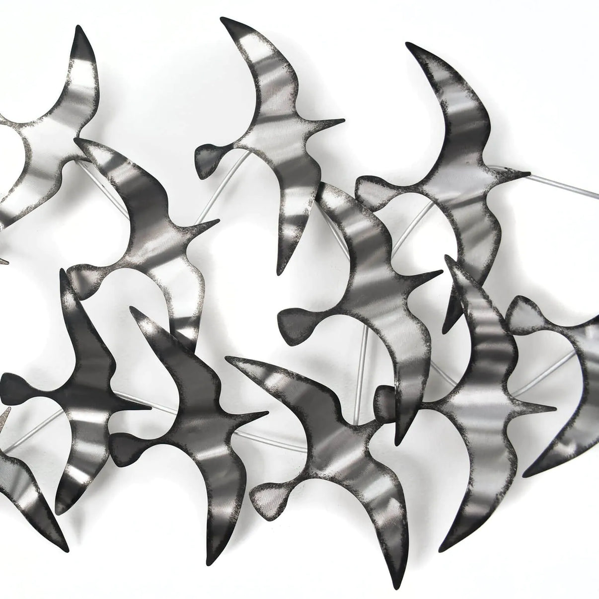 Detailaufnahmen der handgefertigten, silberfarbenen Wandskulptur Möwen aus Metall, die modernes Design und Kunsthandwerk vereint.