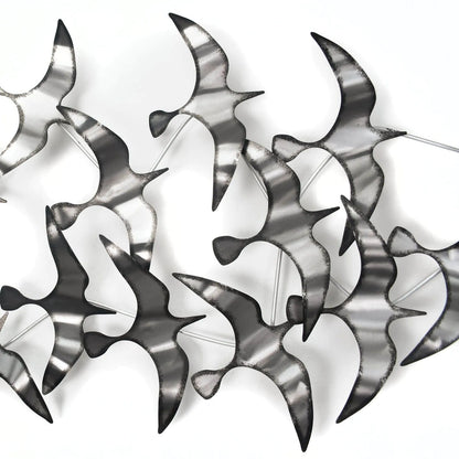Detailaufnahmen der handgefertigten, silberfarbenen Wandskulptur Möwen aus Metall, die modernes Design und Kunsthandwerk vereint.