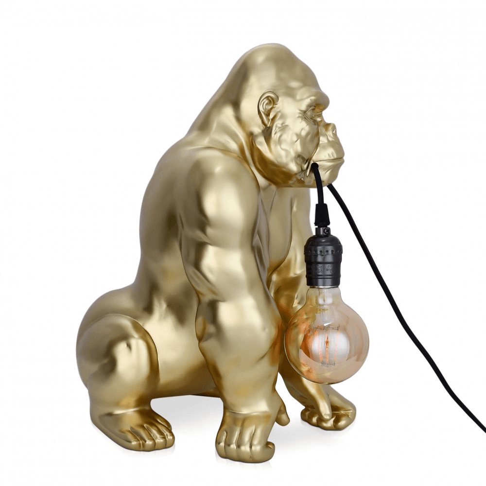Designer Tischlampe Orang-Utan aus Harz mit Goldeffekt – seitliche Ansicht der goldenen Skulptur mit durchscheinender Glühbirne.