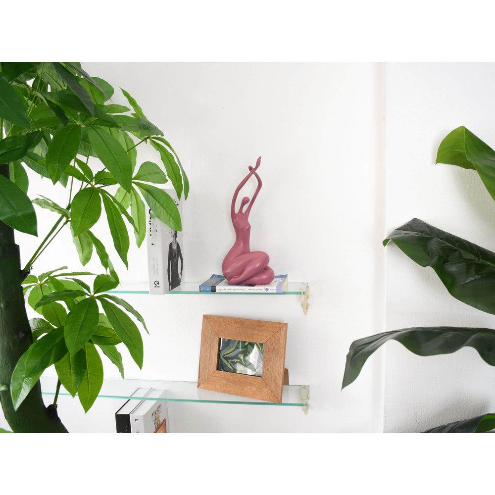 Erwachende Frau – elegante moderne Skulptur in sanftem Rosa, platziert auf einem Regal umgeben von grünen Pflanzen und einem Bilderrahmen, ideal zur Dekoration eines stilvollen Wohnraumes.