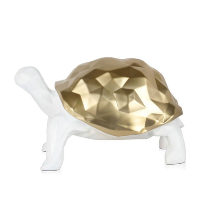Facettierte Goldene Schildkröte – Moderne Harzskulptur mit Metalleffekt, seitliche Ansicht auf einem weißen Untergrund.
