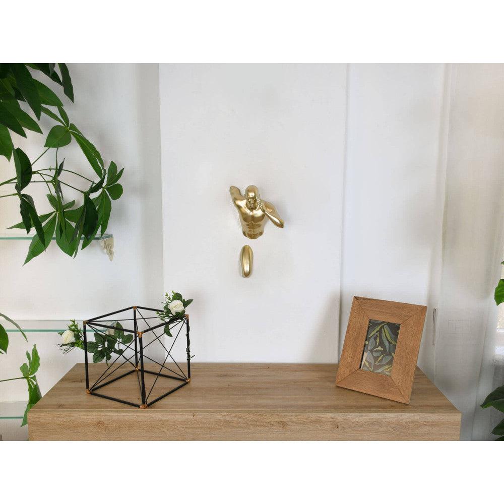 Goldener Läufer – Moderne Wandskulptur aus Metalleffekt-Harz, präsentiert an einer Wand neben Pflanzen und einem Bilderrahmen, stilvolle Interior-Dekoration.