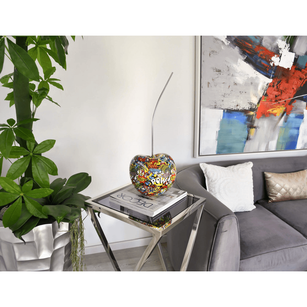 Designer Skulptur aus Kunstharz – Pop Art Meisterwerk in lebendigen Farben, platziert auf einem modernen Wohnzimmertisch neben einer Pflanze und einem Sofa.