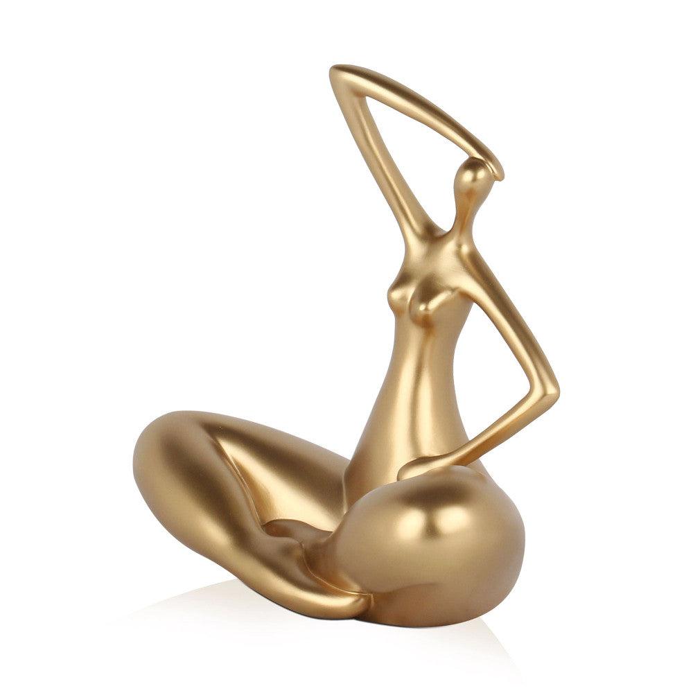 Kleine Evolution – Moderne Kunstharzskulptur mit Goldmetalleffekt, darstellt eine stilisierte Frau in sitzender Pose mit geformtem Körper und kreativem Design.
