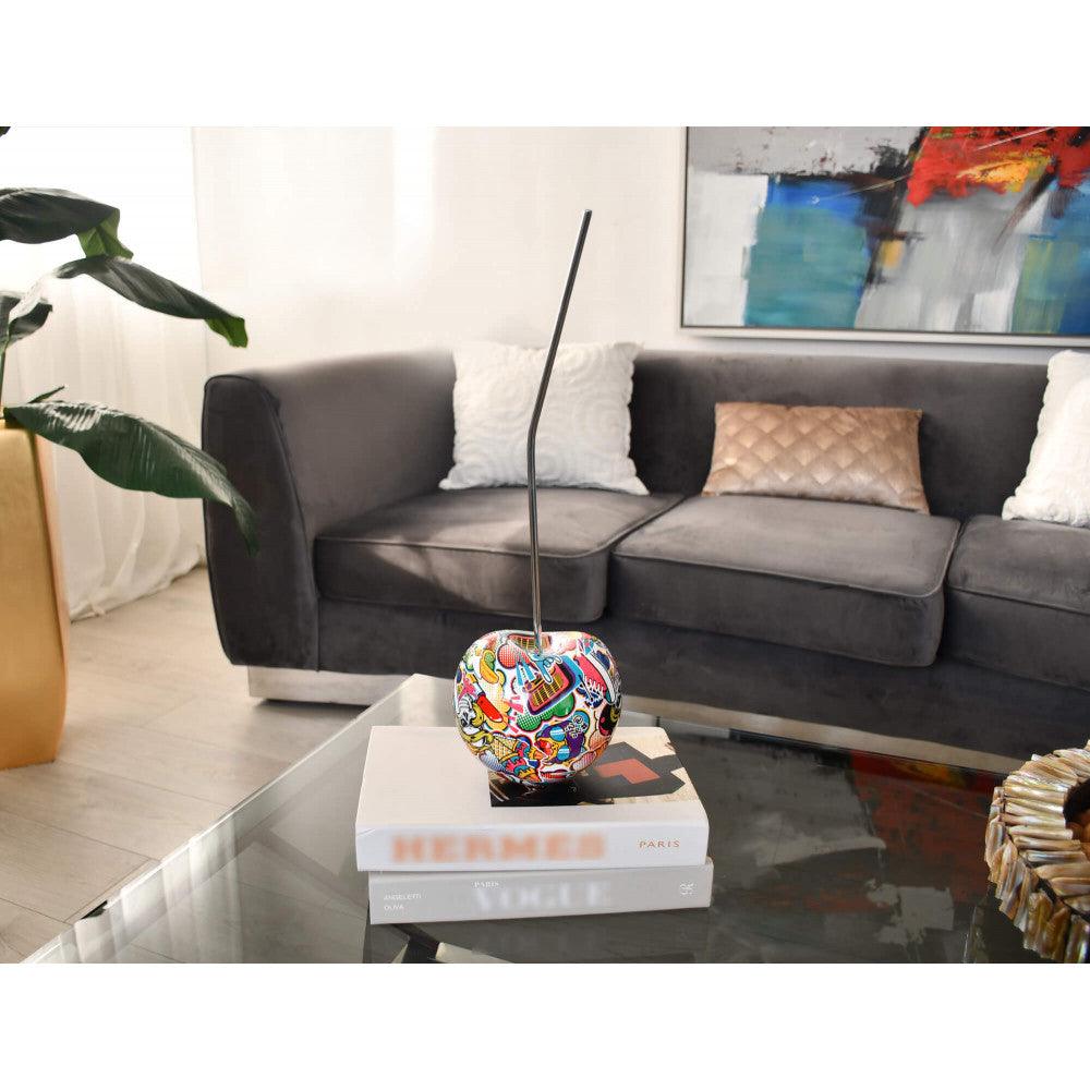 Bunte Kirsche – Auffällige Pop Art Skulptur aus Harz mit Wassertransferdekor, präsentiert auf einem Tisch im Wohnzimmer.