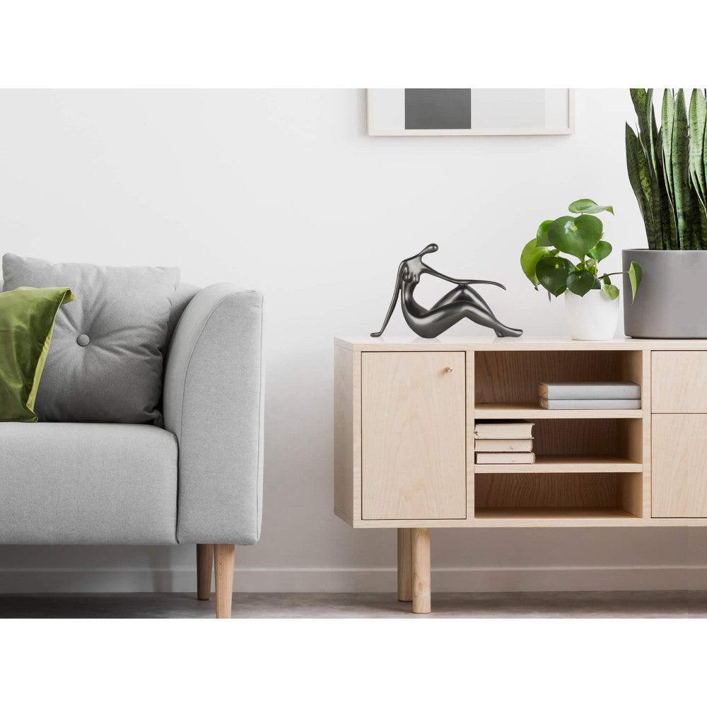Kleine Ruhe: Elegante Skulptur in Anthrazit mit Metalleffekt, Dekoration auf einem modernen Sideboard.