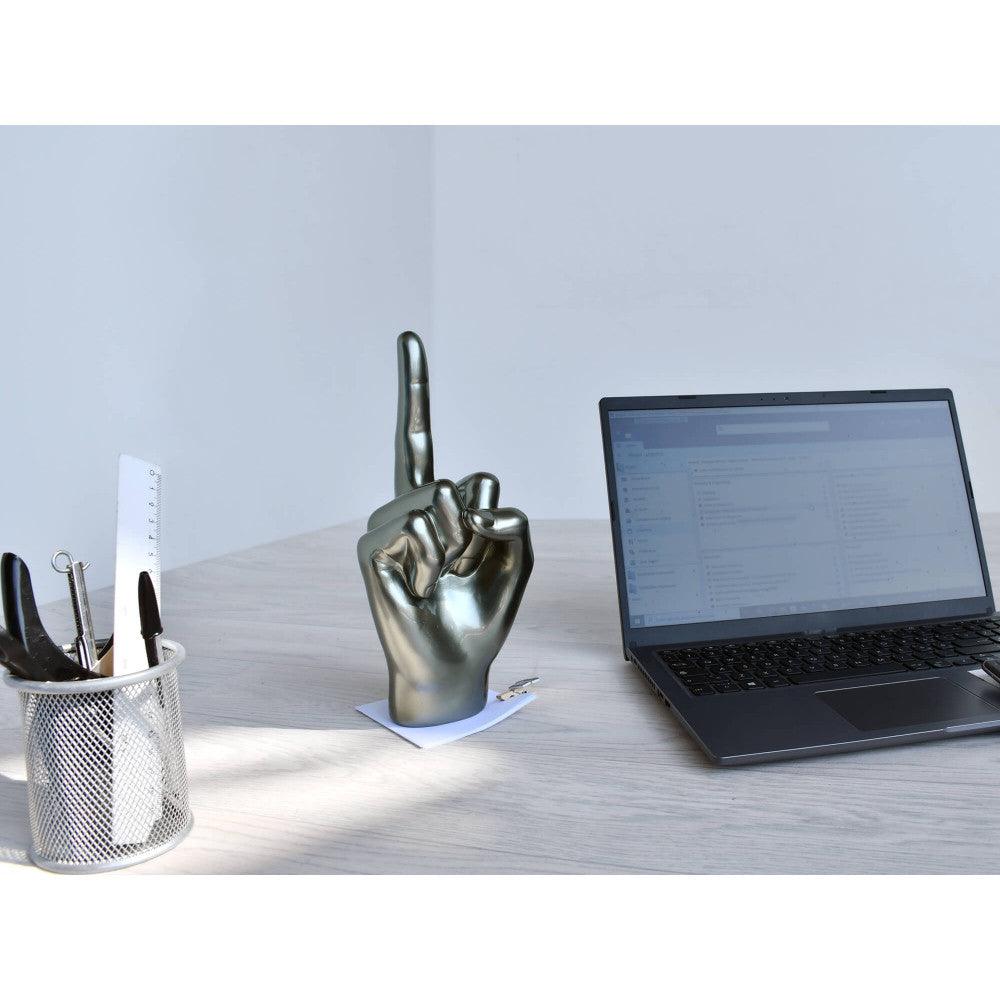 Moderne Skulptur "Anthrazit Mittelfinger" aus Kunstharz mit Metalleffekt, platziert auf einem Schreibtisch neben einem Laptop und Bürobedarf.