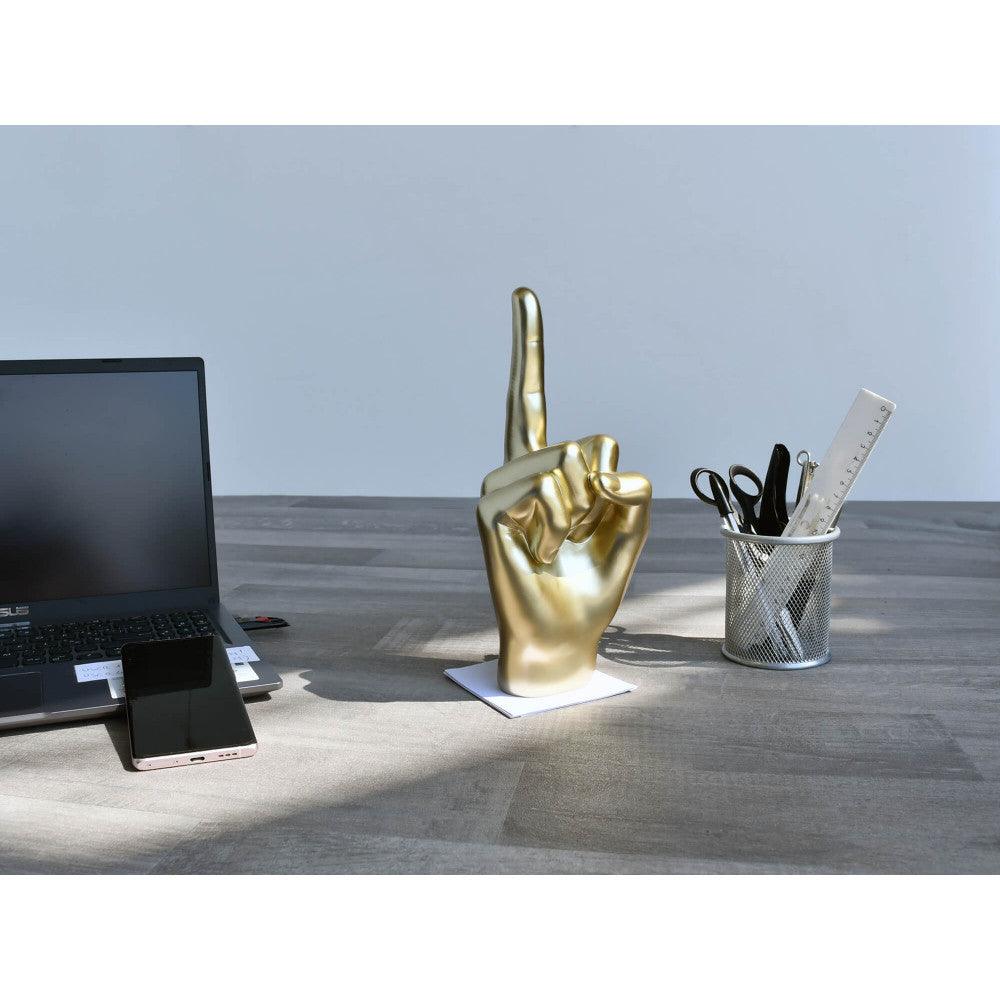 Moderne Mittelfinger Skulptur aus Harz mit Metalleffekt auf einem Schreibtisch neben einem Laptop und Bürobedarf - 28 x 11 x 11 cm.