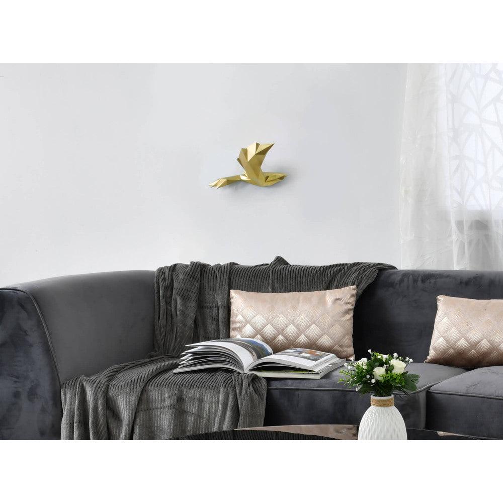 Elegante Origami-Vogel-Skulptur aus Kunstharz mit goldenem Metalleffekt, dekorativ am Wand für modernes Wohnen, auf einer Couch mit dekorativen Kissen platziert.