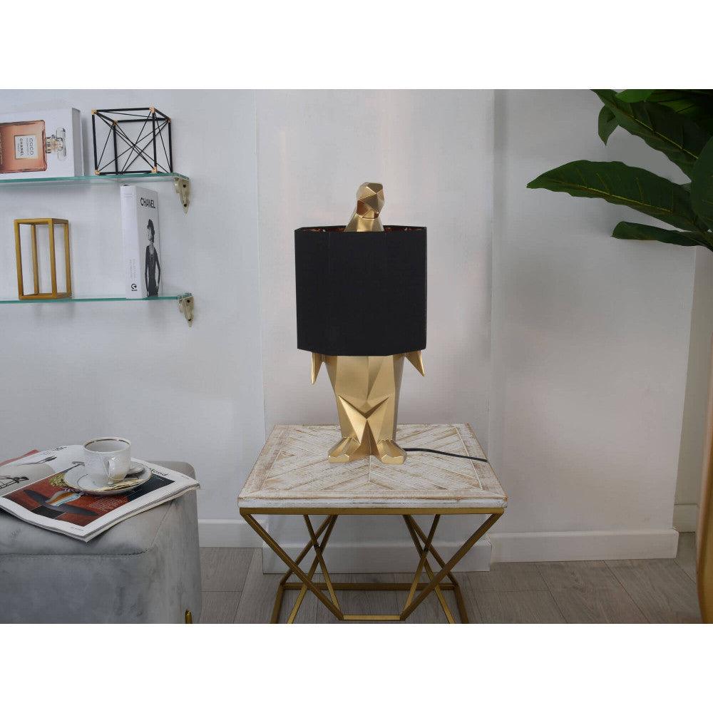 Pinguin Gold Tischlampe – stilvolles Einrichtungselement auf einem Tisch, elegantes Design mit schwarzem Lampenschirm für eine gemütliche Atmosphäre.