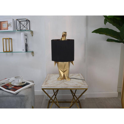Pinguin Gold Tischlampe – stilvolles Einrichtungselement auf einem Tisch, elegantes Design mit schwarzem Lampenschirm für eine gemütliche Atmosphäre.