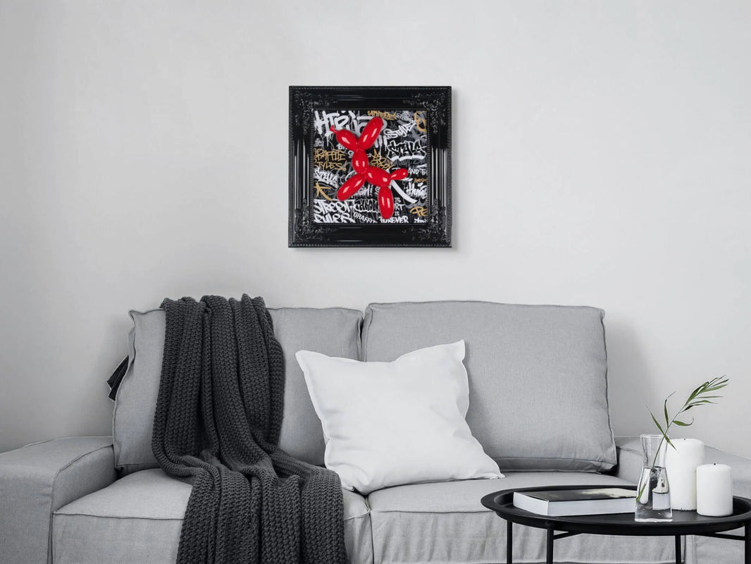 Pop-Art Wanddekoration: Ballonhund Skulptur mit neobarocker Holzrahmen 46x46cm, Schwarz - das Kunstwerk wird im modernen Wohnraum über einem grauen Sofa präsentiert.