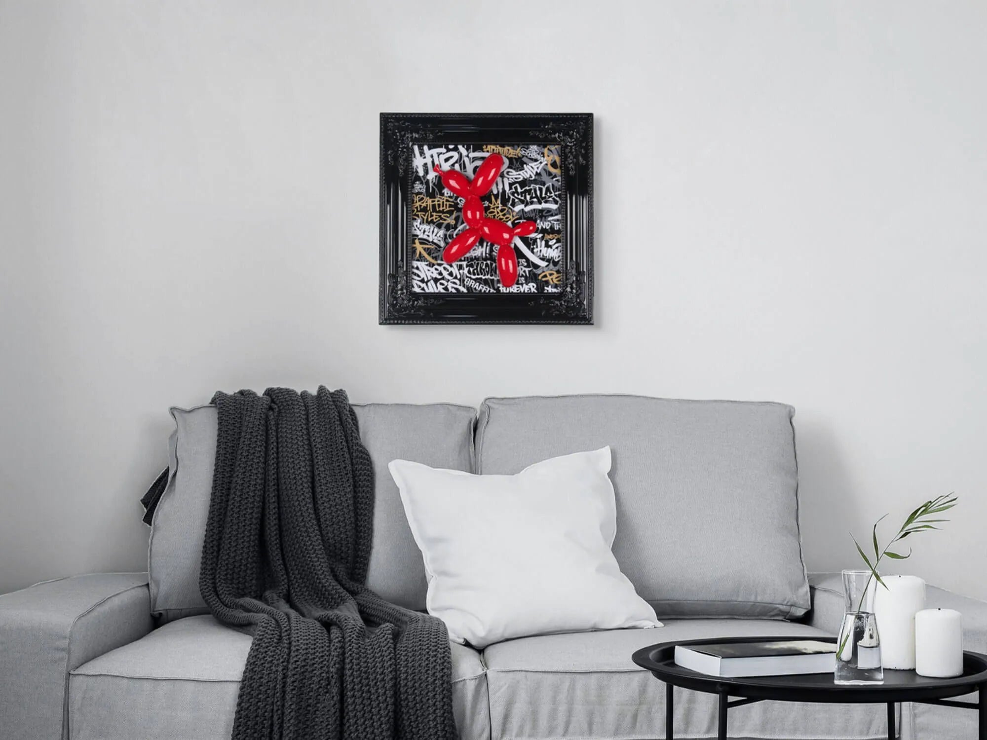 Pop-Art Wanddekoration: Ballonhund Skulptur mit neobarocker Holzrahmen 46x46cm, Schwarz - das Kunstwerk wird im modernen Wohnraum über einem grauen Sofa präsentiert.