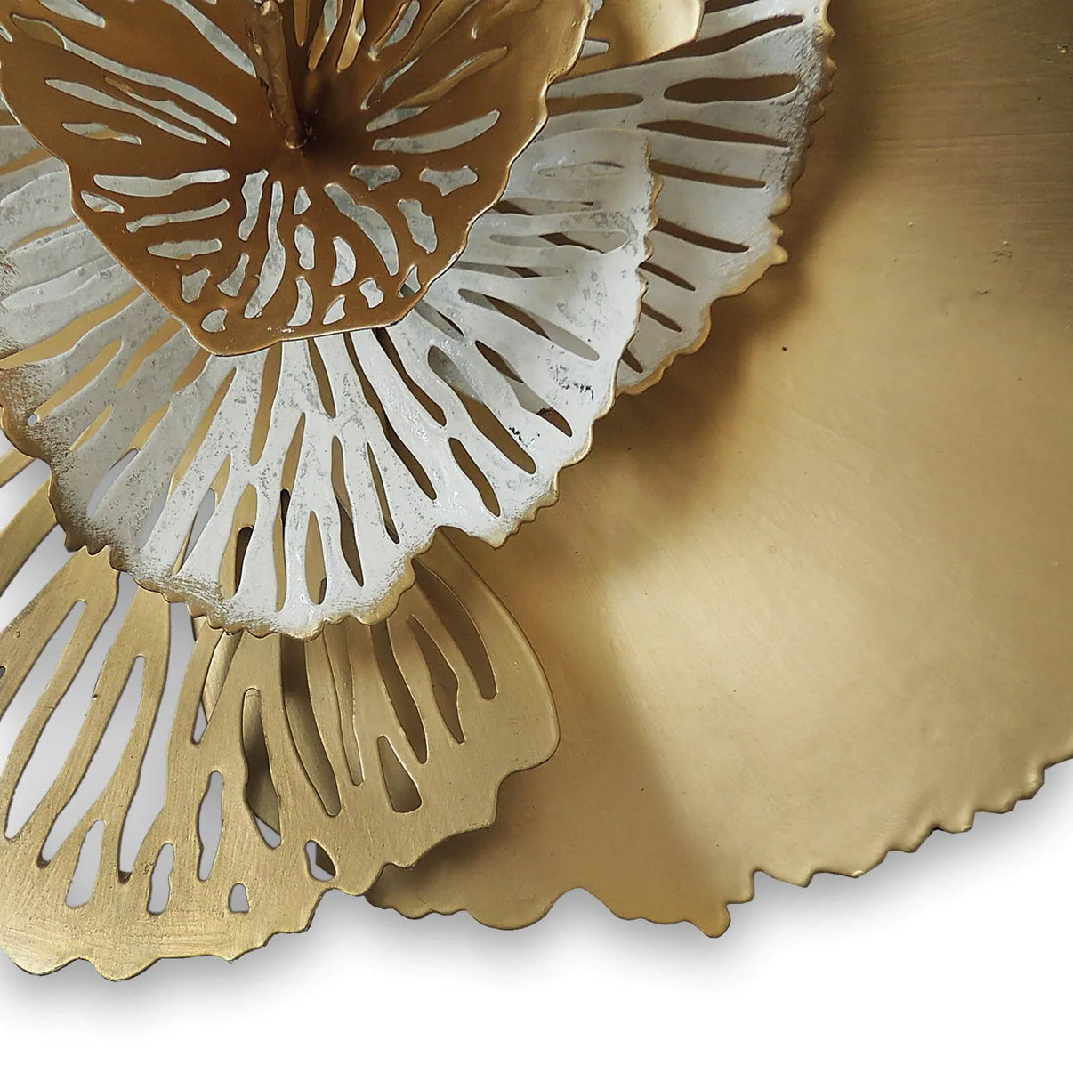 Handgefertigte Wandskulptur: Perforierte Blumen in Gold und Silber – Blick auf die polierte Oberfläche reflektierendes Licht für besondere Ausstrahlung