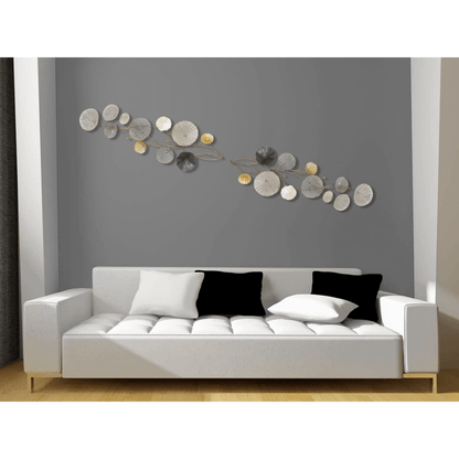 Stilisierte Wanddekoration aus Metall: Elegante Seerosen in Grau und Gold, präsentiert über einem modernen Sofa in einem stilvollen Raum.