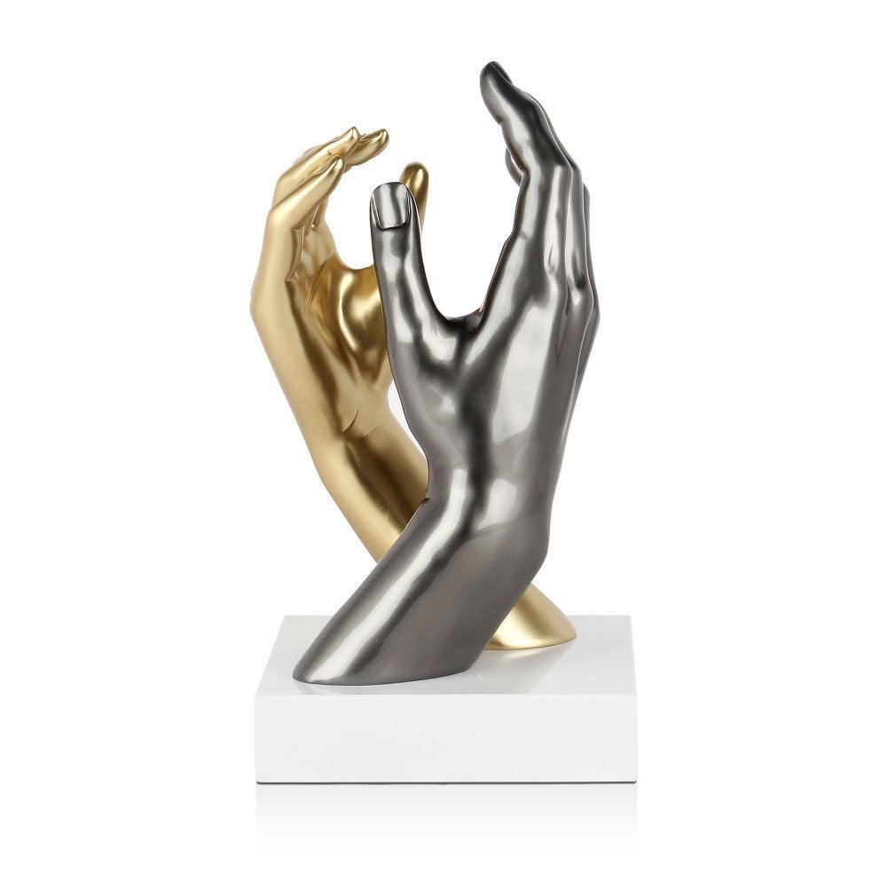 Skulptur "Tiefe Vereinigung" in modernem Stil, deren goldene und silberne Hände in einem beeindruckenden Metalleffekt strahlen, platziert auf einem weißen Marmorsockel.