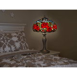 Tischlampe mit roten Rosen und hellblauen Blumen am Bett