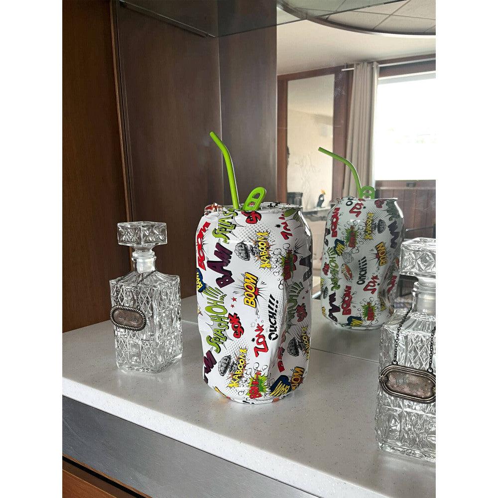 Zerdrückte Dose Pop Art Skulptur in einem modernen Wohnambiente, umgeben von glasklaren Dekorationsobjekten auf einem Tisch.